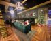 Lounge decorated with a Christmas tree, set for a corporate holiday party