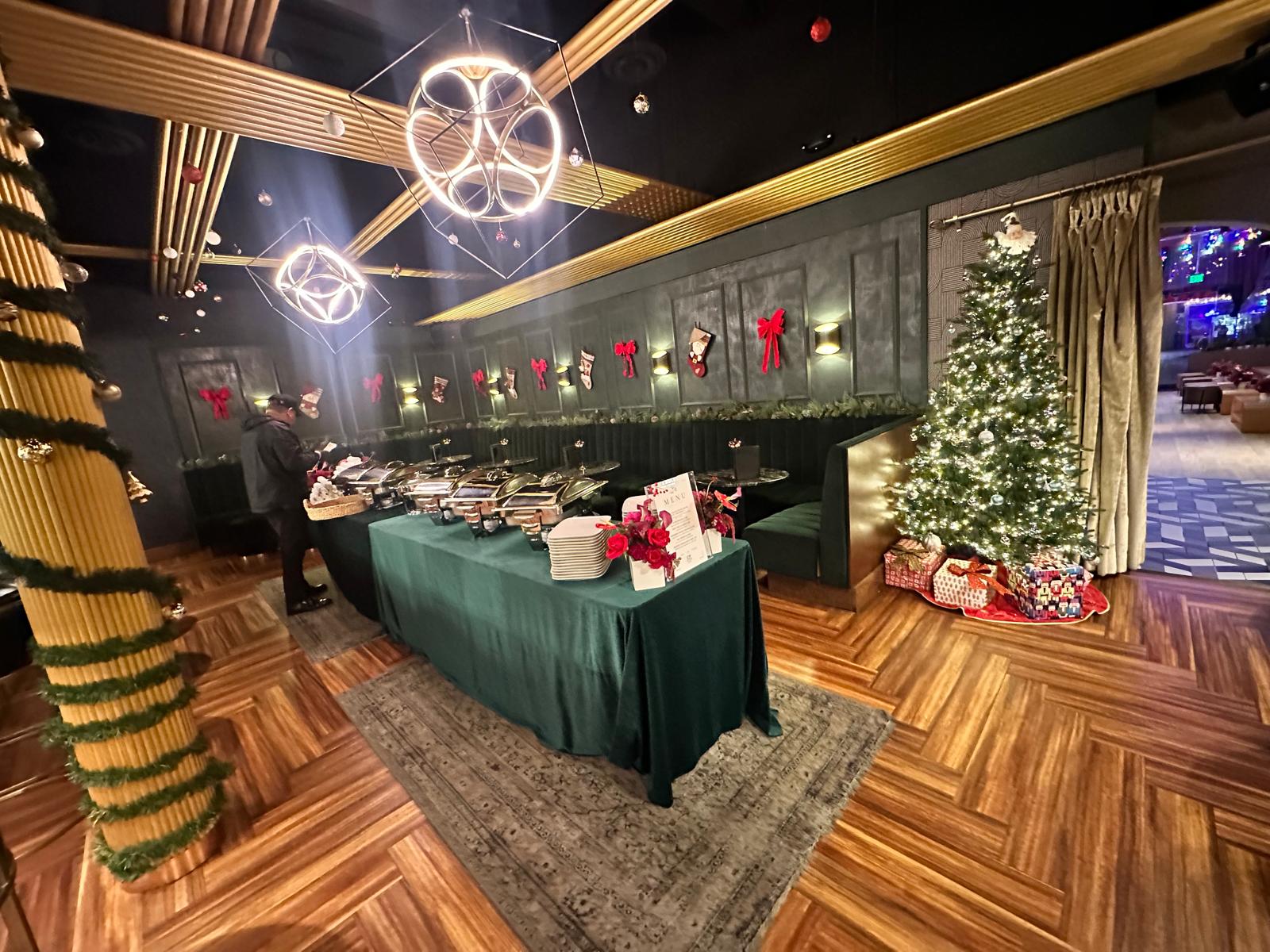Lounge decorated with a Christmas tree, set for a corporate holiday party
